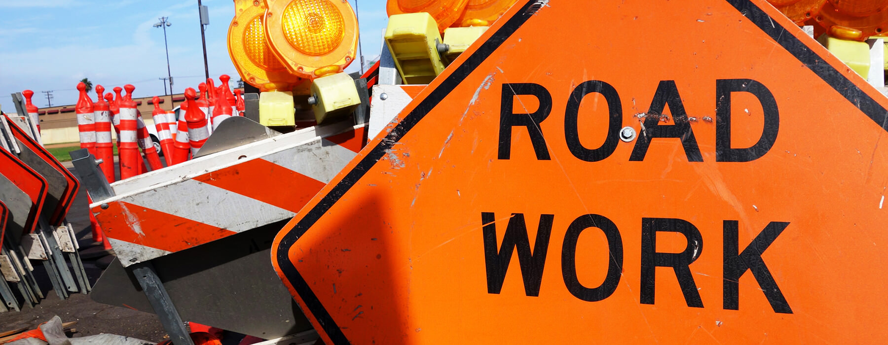 A road work sign with construction barricades.